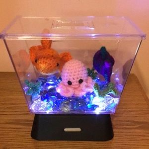 Plastic fish tank with crochet fish and octopus.